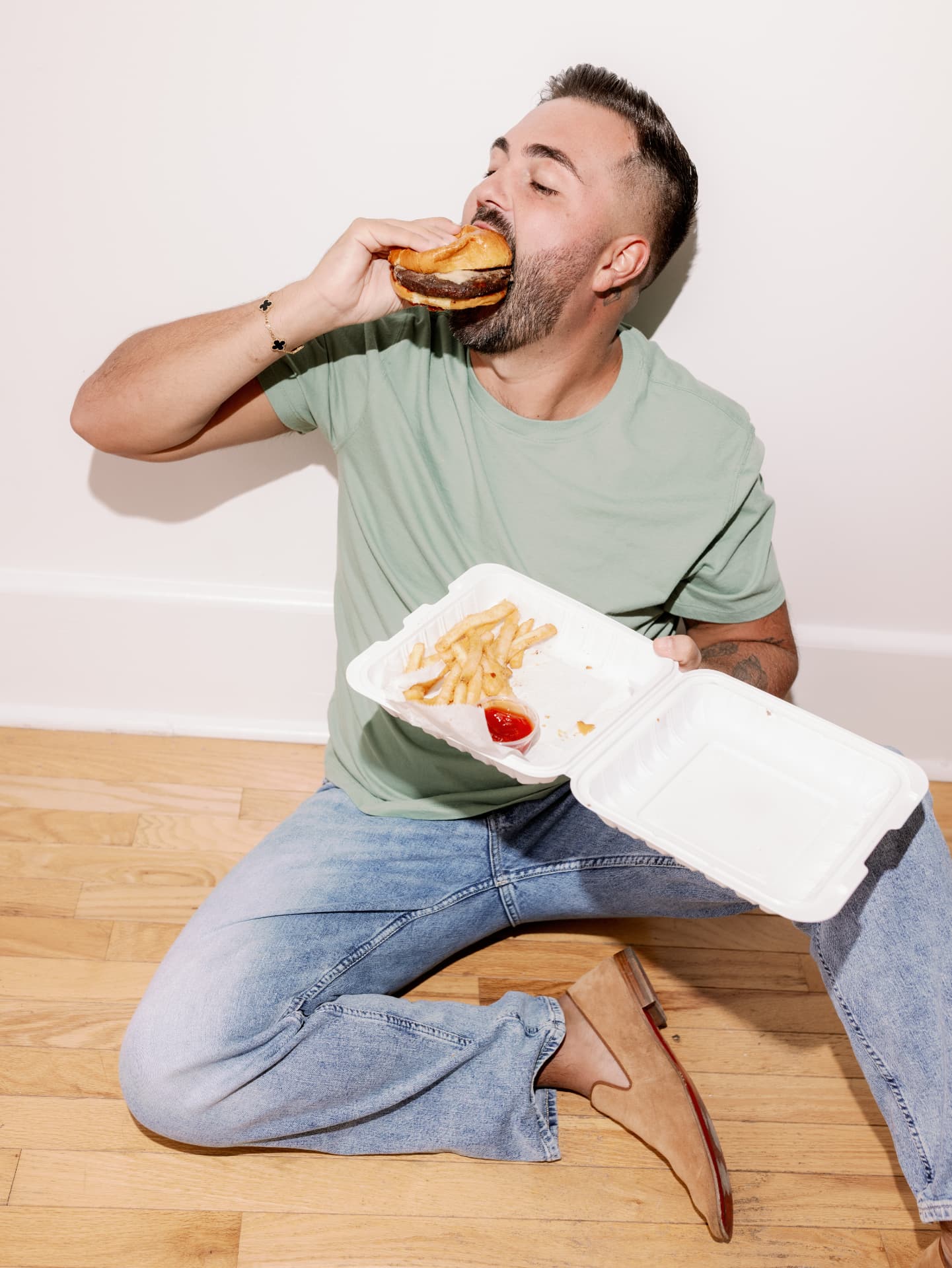 Dom C eating a burger and fries on the floor