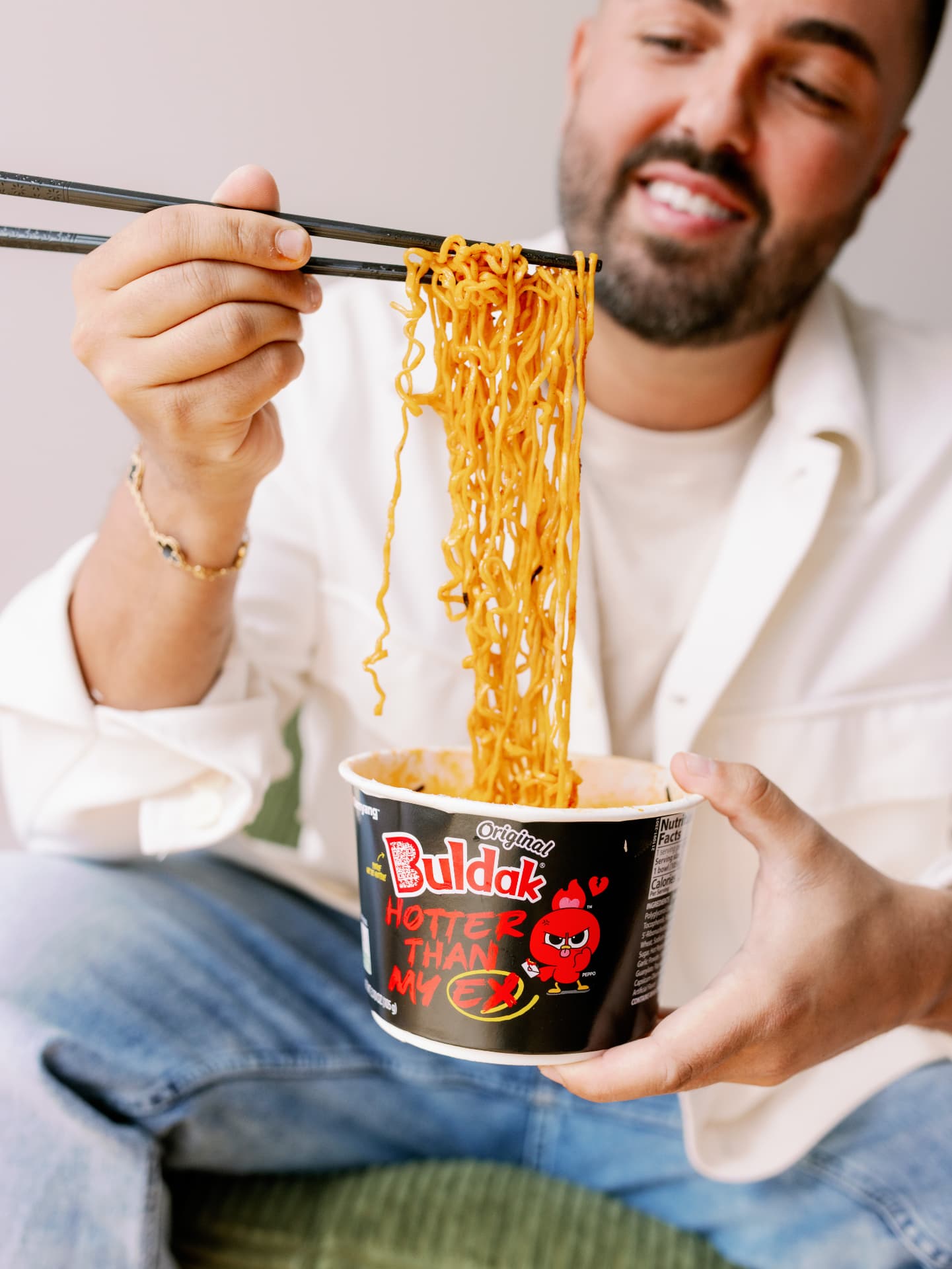 Dom C pulling noodles from a cup of Buldak ramen
