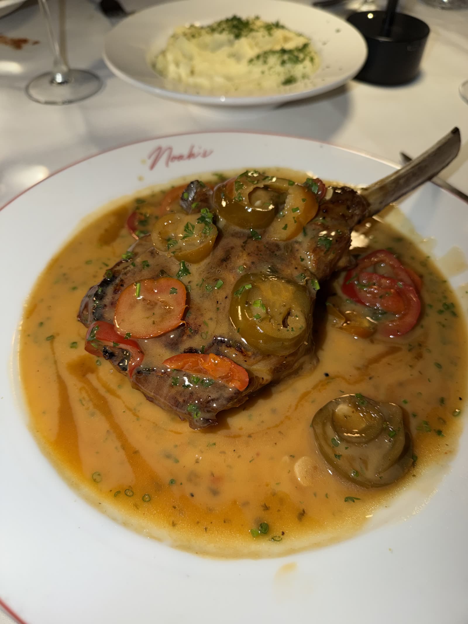 Osso buco in a wide bowl of sauce at an Italian restaurant