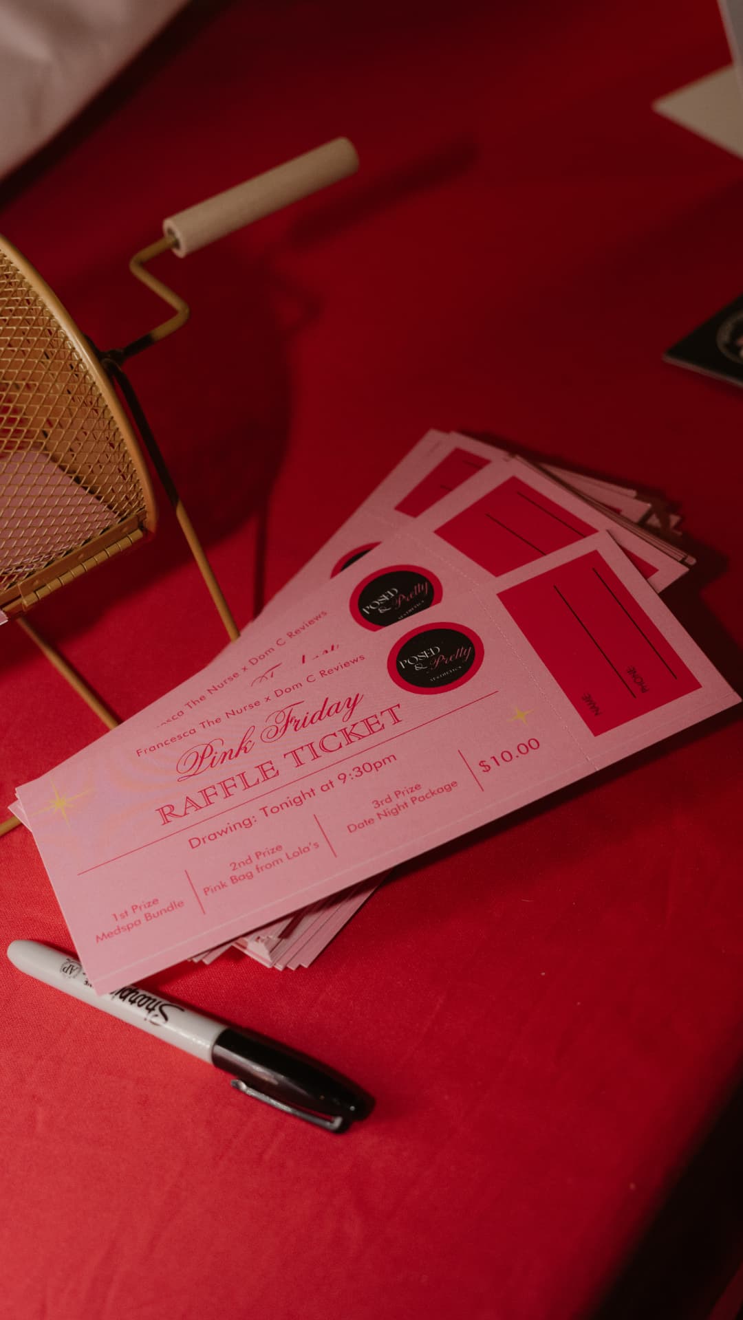 Pink Friday raffle tickets on the table next to the raffle drum